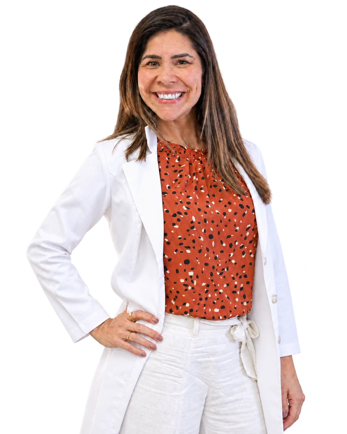 Natália Amorim sorrindo, com jaleco branco, blusa terracota estampada e a mão no quadril